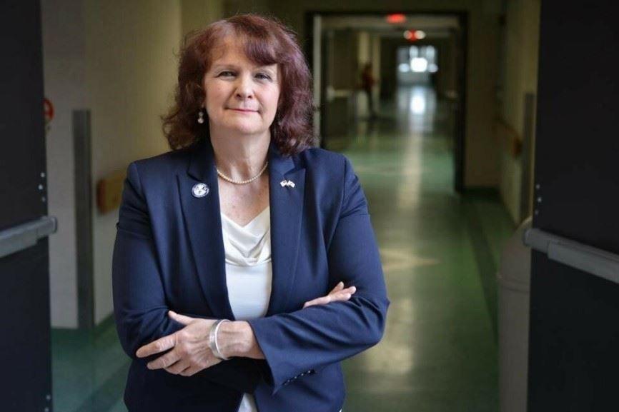 Ret Colonel Cheryl Lussier Poppe standing in hallway