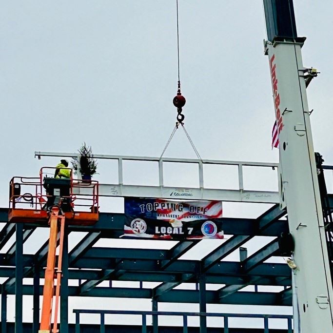 The Topping Off beam is hoisted in place and installed
